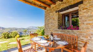 a wooden table and chairs on a patio at Cortijo Noguera La Taha - Pitres by Ruralidays in Granada