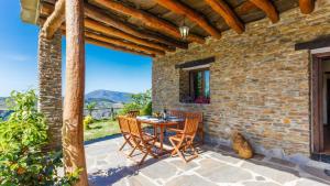 a patio with a table and chairs on a brick wall at Cortijo Noguera La Taha - Pitres by Ruralidays in Granada