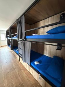 three bunk beds in a room with blue beds at Albergue Freixo in Palas de Rei