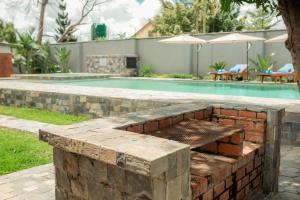 a brick fire pit next to a swimming pool at Chandamali Bed & Breakfast in Kitwe