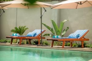 two chairs with umbrellas next to a swimming pool at Chandamali Bed & Breakfast in Kitwe