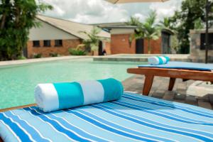 a swimming pool with a blue and white striped table cloth at Chandamali Bed & Breakfast in Kitwe