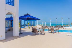 a patio with a table and chairs and a pool at Pallax hotel in Zarzis