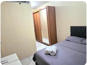 a bedroom with a bed with two towels on it at AP Climatizado aconchego com Mercado em frente in Vitória da Conquista +14 photos