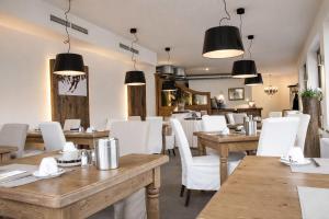a restaurant with wooden tables and white chairs at ALPENNEST - Balcony & Sauna Access in Seefeld in Tirol