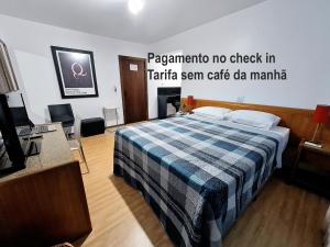 a hotel room with a bed with a plaid blanket at Hotel Germânia in Joinville +141 photos