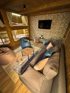 a living room with a couch and a tv at Chata Biela Stopa in Tatranská Lomnica