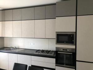 a kitchen with a stove and a microwave at Residenza Thiene Centro in Thiene