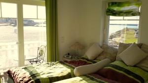 a living room with a couch and a large window at Strandhaus Libelle - direkt am Strand der Ostsee in Kappeln