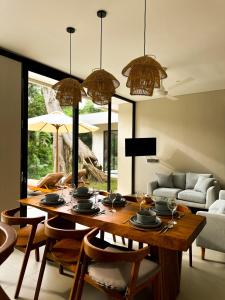 a living room with a wooden table and chairs at 3BR Tala Villa Ubud in Ubud