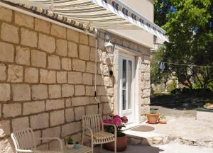 eine Terrasse mit zwei Stühlen und einem Sonnenschirm in der Unterkunft Joy4You in Čilipi