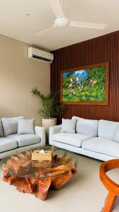 a living room with two white couches and a table at 3BR Tala Villa Ubud in Ubud