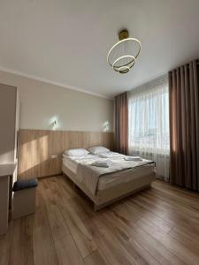 a bedroom with a bed and a large window at Alcha Hotel Karakol in Karakol