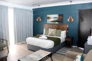 a bedroom with a bed and a blue wall at Oria Guest House in Cape Town +23 photos