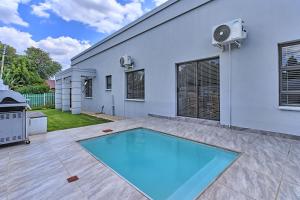 a swimming pool in the backyard of a house at 3 Kiaat Suites in Klerksdorp