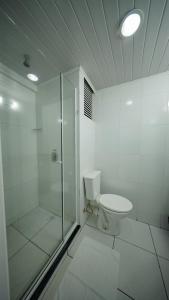 a white bathroom with a shower and a toilet at LH Plaza Hotel in Chapecó +39 photos