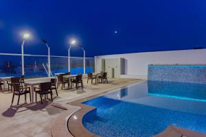 a patio with a table and chairs next to a swimming pool at Pallax hotel in Zarzis