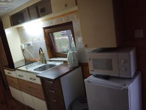 a small kitchen with a sink and a microwave at Domček pri vode Pohoda in Teplý Vrch