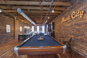 a pool table in a room with a brick wall at The Library-Downtown Nashville Luxury Penthouse Printers Alley Steps to Broadway in Nashville