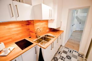 - une cuisine avec des placards blancs et un évier dans l'établissement Loft Le Saint Louis by La Chambre à Coté, à Metz