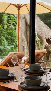 a table with plates and wine glasses on it at 3BR Tala Villa Ubud in Ubud