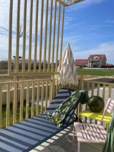 a deck with a chair and a hammock on a porch at Sunday Apartamenty SPA Miraż in Ustronie Morskie