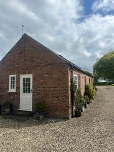 a brick building with a white door and some plants at The Studio in Willerby