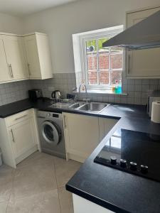 a kitchen with a sink and a washing machine at The Studio in Willerby