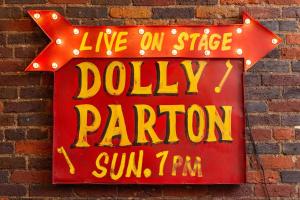 a sign on a brick wall that reads live on stage dolly parking at The Dolly Printer's Alley Nashville- 2 Blocks to Broadway in Nashville