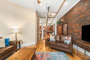 a living room with two couches and a brick wall at The Dolly Printer's Alley Nashville- 2 Blocks to Broadway in Nashville +16 photos