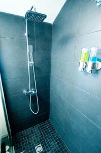Łazienka z prysznicem wyłożona jest niebieskimi kafelkami. w obiekcie Loft Le Saint Louis by La Chambre à Coté w Metz