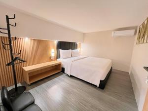 a hotel room with a white bed and a chair at Verse Hotel Cirebon in Cirebon +84 photos