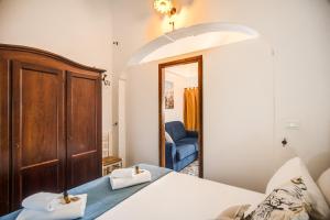 a bedroom with a bed and a blue chair at Terrazza Anvi Mare & Relax in Polignano a Mare +19 photos