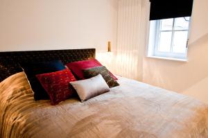 um quarto com uma cama com almofadas e uma janela em Loft Le Saint Louis by La Chambre à Coté em Metz