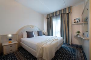 
a hotel room with a bed and a dresser at CDH Hotel Villa Ducale in Parma
