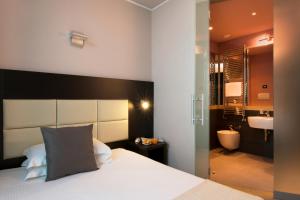 a hotel room with a large bed and a large mirror at CDH Hotel Villa Ducale in Parma