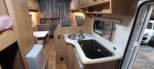 a small bathroom with a sink in an rv at Camper Rental Elbasan in Elbasan