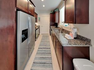 a kitchen with wooden cabinets and a refrigerator at Dawn 315-saltwater Escape in Galveston