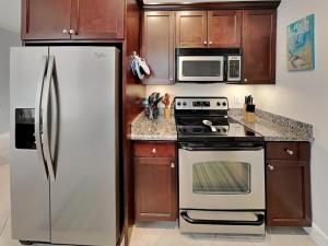 a kitchen with stainless steel appliances and wooden cabinets at Dawn 315-saltwater Escape in Galveston