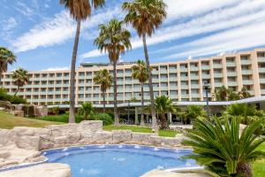 a resort with a swimming pool and palm trees at RVHotels Ametlla Mar in L'Ametlla de Mar