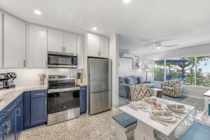 a kitchen and living room with blue cabinets and a table at Sea Turtle Bungalow - 1136-2 in Siesta Key