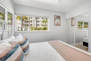 a bedroom with a large bed and two windows at Sea Turtle Bungalow - 1136-2 in Siesta Key +43 photos