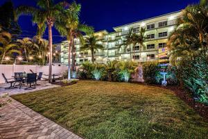 a building with palm trees in front of a yard at Sea Turtle Bungalow - 1136-2 in Siesta Key