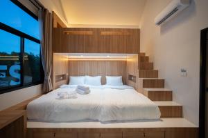 a bedroom with a white bed with a staircase at Sea Vibes Pool Villa in Ban Bo So +24 photos
