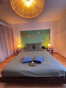 a bedroom with a large bed with two blue pillows at Pueblo Bonito Epinal avec Terrasse in Épinal