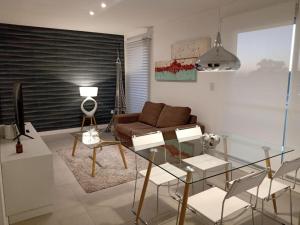a living room with a glass table and a couch at Be Haus Temporary Apartments in San Luis