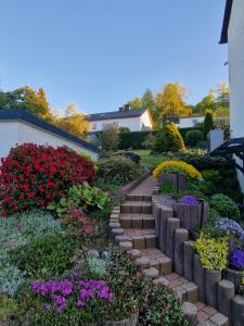 a garden with colorful flowers and stepping stones at Waldpanorama Schildberg in Lügde