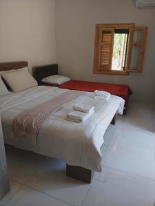 a bedroom with a large bed and a window at Nafplio Garden House in Nea Tiryntha