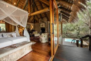 a bedroom with a bed and a living room at Jabulani Safari Relais & Chateaux in Kapama Private Game Reserve
