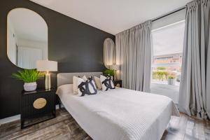 a bedroom with a large bed and a large window at SmartSleep Apartments in Glasgow